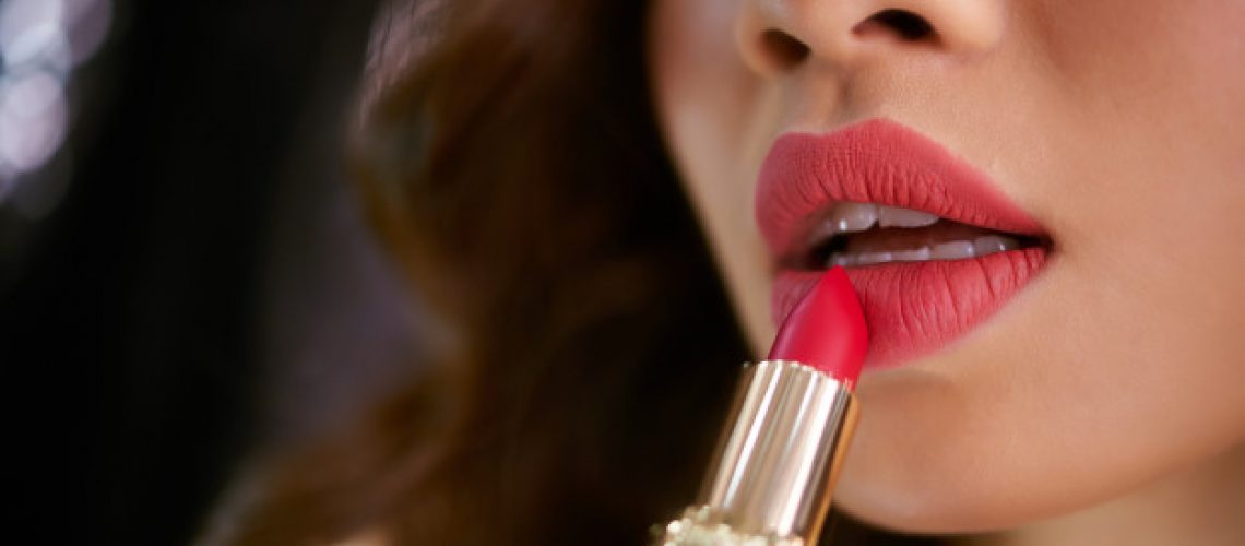 closeup-lipstick-touching-plump-red-female-lips_1098-19287